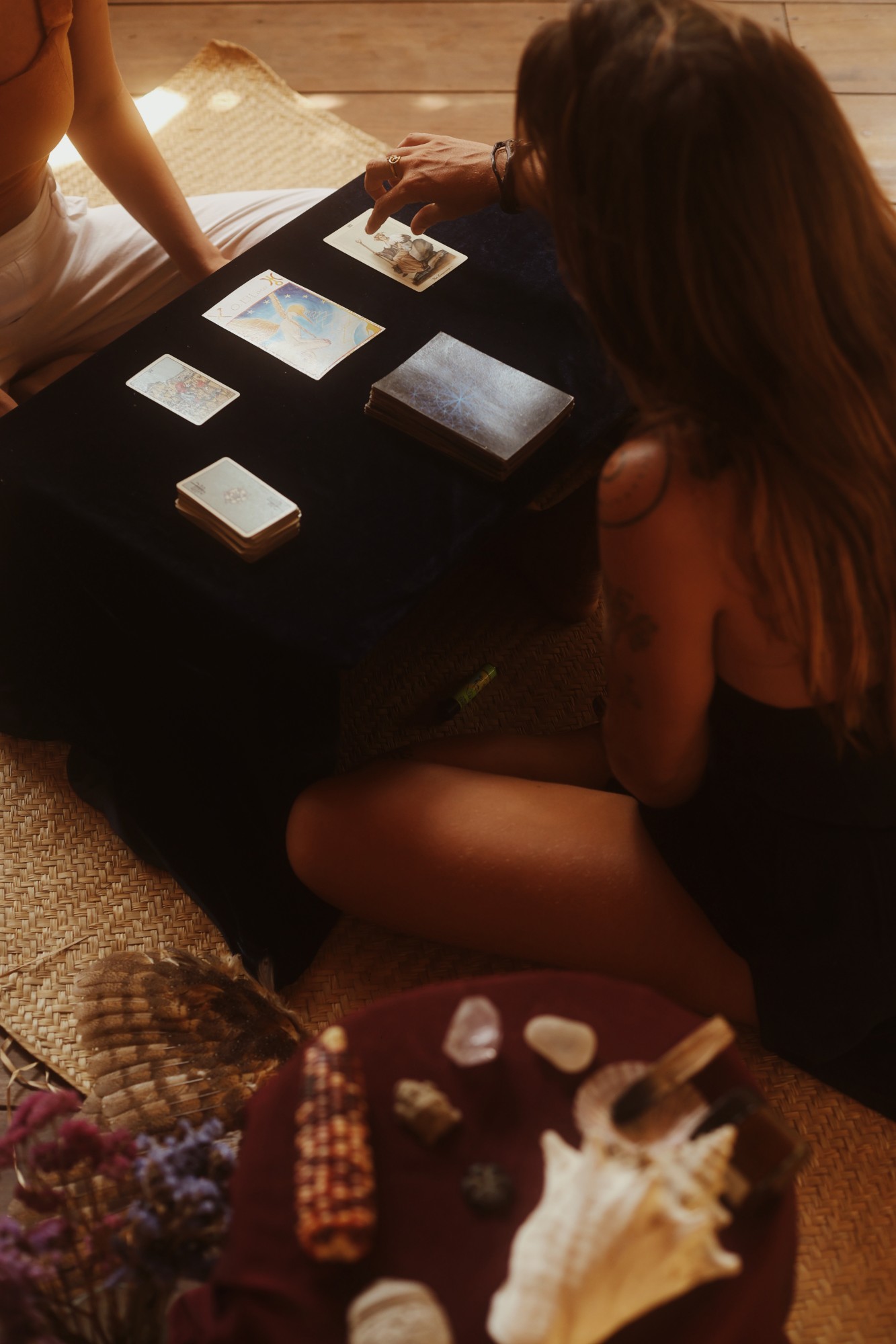 Two people sharing a tarot reading on a velvet-covered table